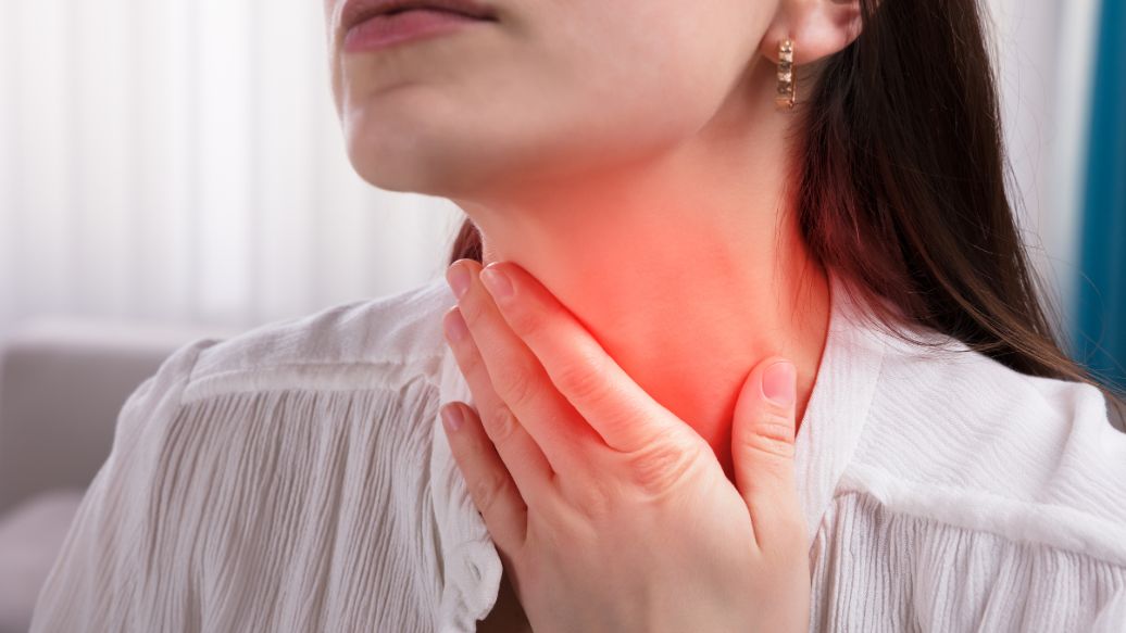 Woman touching sore throat